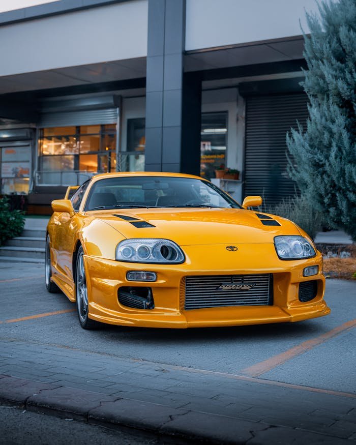 A striking yellow Toyota Supra parked outside a modern building in Ankara, Türkiye.